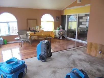 Living room with arched windows, a dehumidifier and air movers drying the floor in Pico Rivera, CA