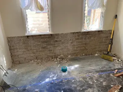 Room with the damaged drywall stripped down to the brick and the floor cleared for drying in Pico Rivera, CA