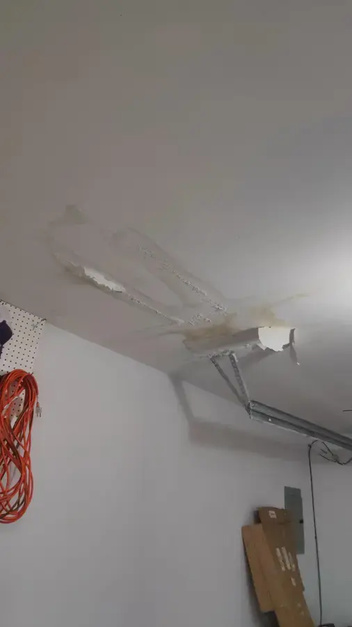 Water-stained ceiling drywall peeling around a pipe opening in Pico Rivera, CA