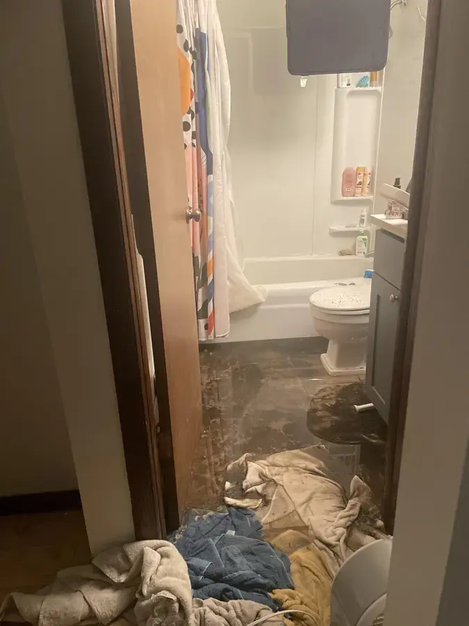 Bathroom floor covered by a sewage backup with soiled towels in Pico Rivera, CA